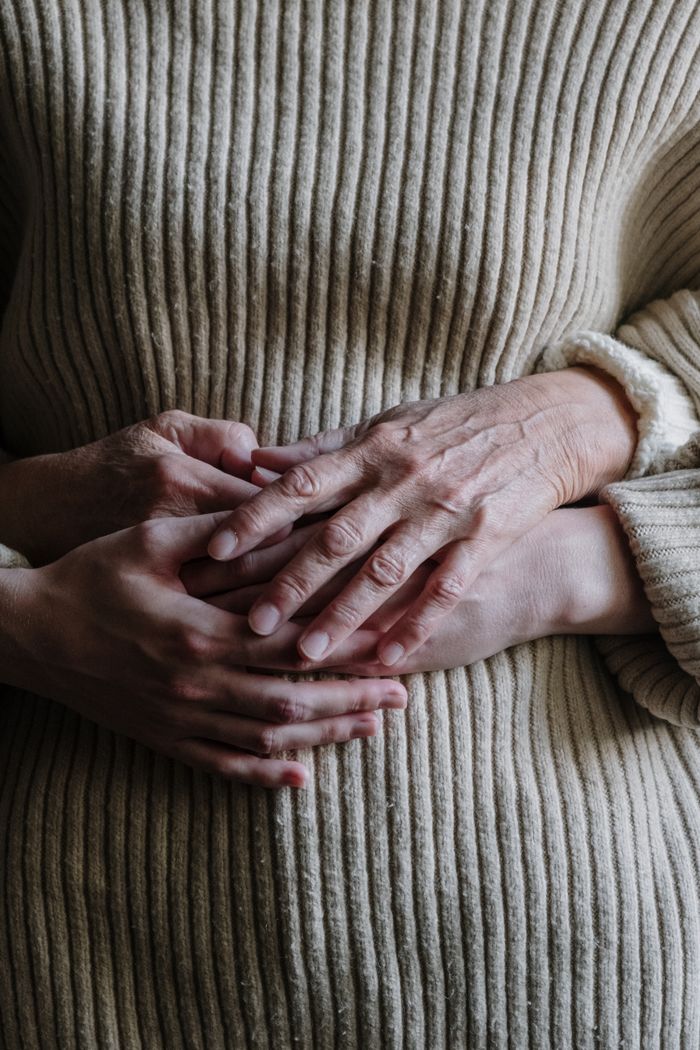 Close-up of two pairs of hands representing connection and comfort.