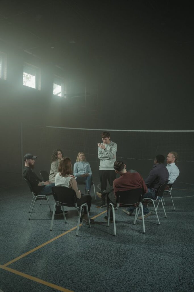 Crafting Captivating Headlines: Your awesome post title goes here A group of adults engaged in a therapy session within a calm, smoky indoor environment.